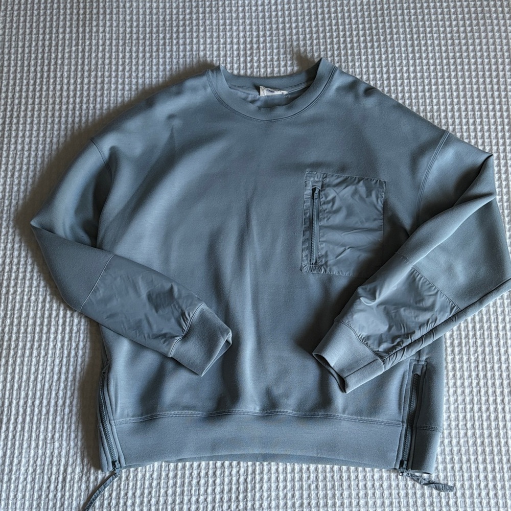 Women’s Blue Crew Neck with Pocket Detail and zip sides.